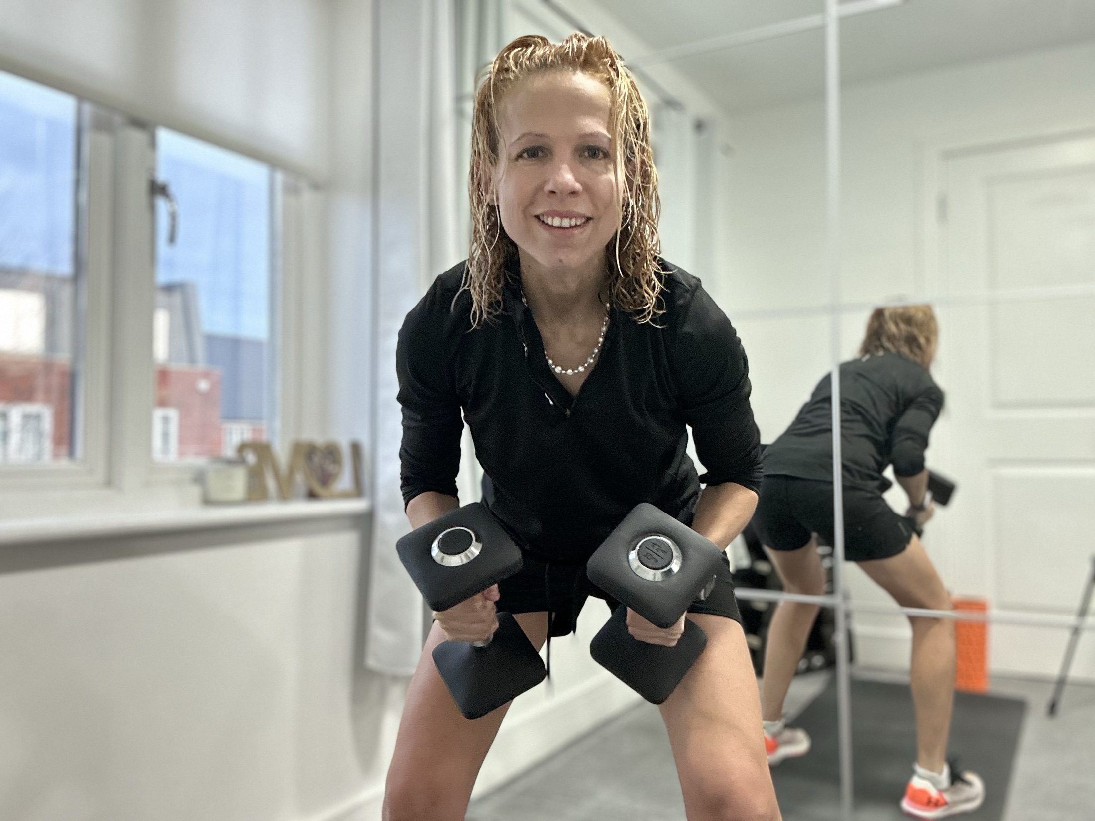 Moria Bennett coaching with dumbbells in her private training studio